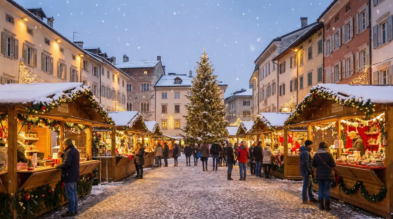 Persone passeggiano tra le bancarelle decorate di un mercatino di Natale innevato in una piazza italiana